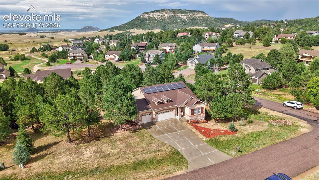Image 37 of 43: Ranch-style exterior with a shingle roof and solar panels