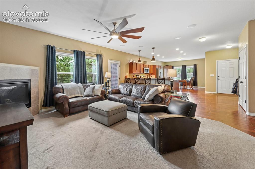 Image 8 of 43: Spacious living area featuring a fireplace with a tiled surround, recessed 
