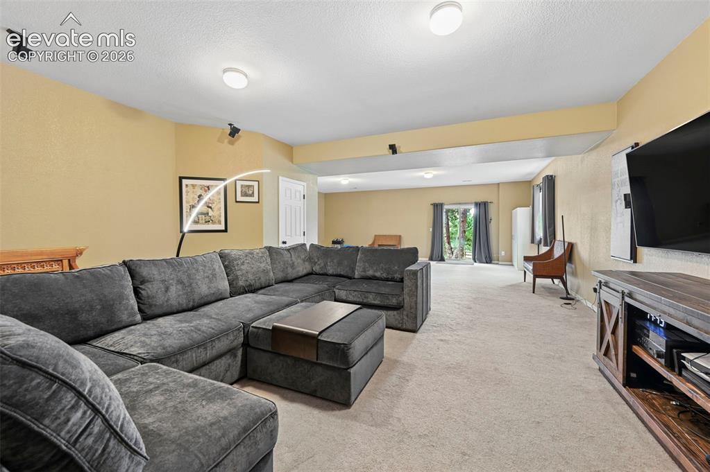 Image 9 of 43: Spacious living area featuring neutral carpeting and recessed lighting