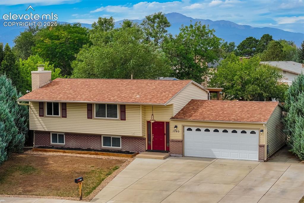 Image 1 of 44: Oversized garage & extended concrete driveway with the Rocky Mountains as y