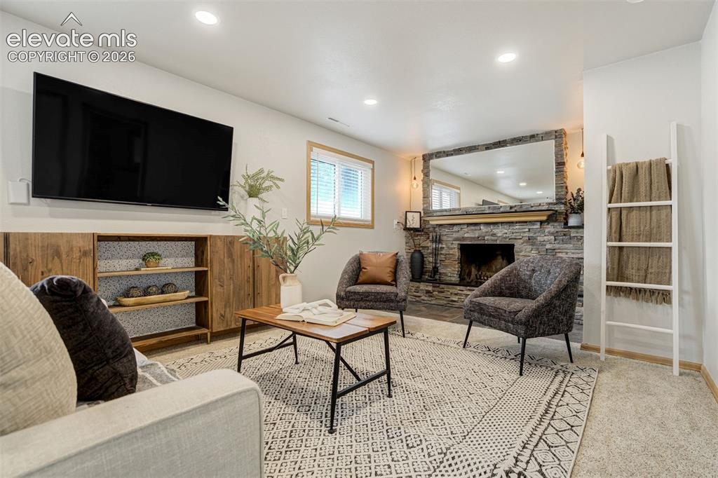 Image 19 of 44: Enter: the basement. Where the wood-burning fireplace makes “cozy night in”