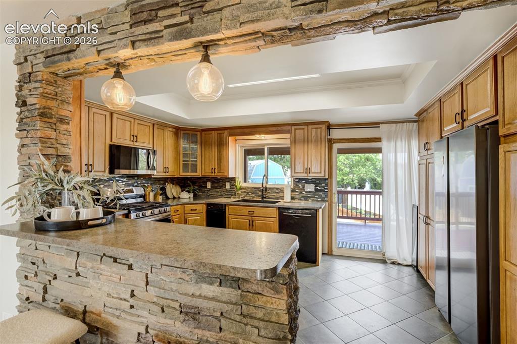 Image 7 of 44: Stacked stone accent wall leading into the kitchen. 
