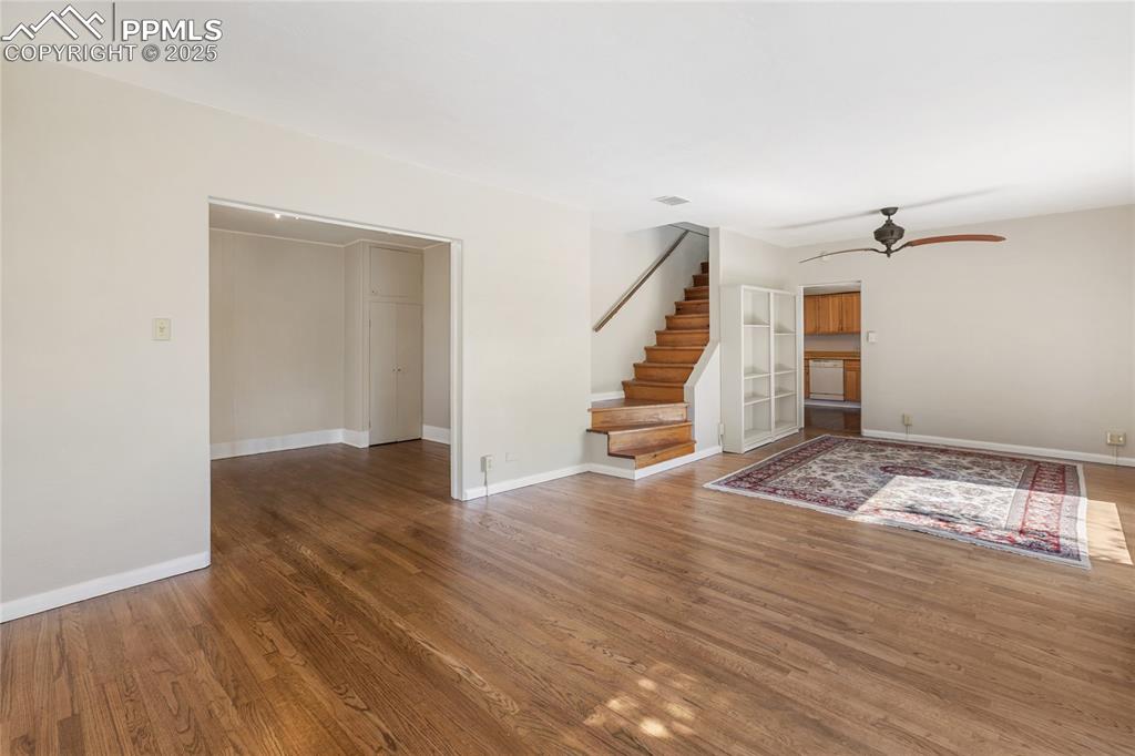 Image 12 of 49: Unfurnished living room with wood finished floors and ceiling fan