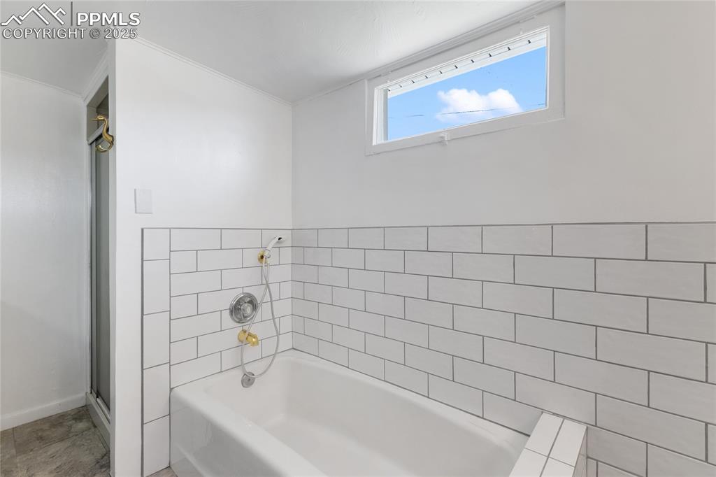 Image 22 of 49: Bathroom with a bath and a shower stall
