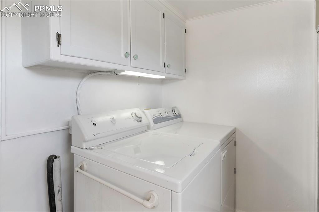 Image 23 of 49: Laundry room with cabinet space and separate washer and dryer