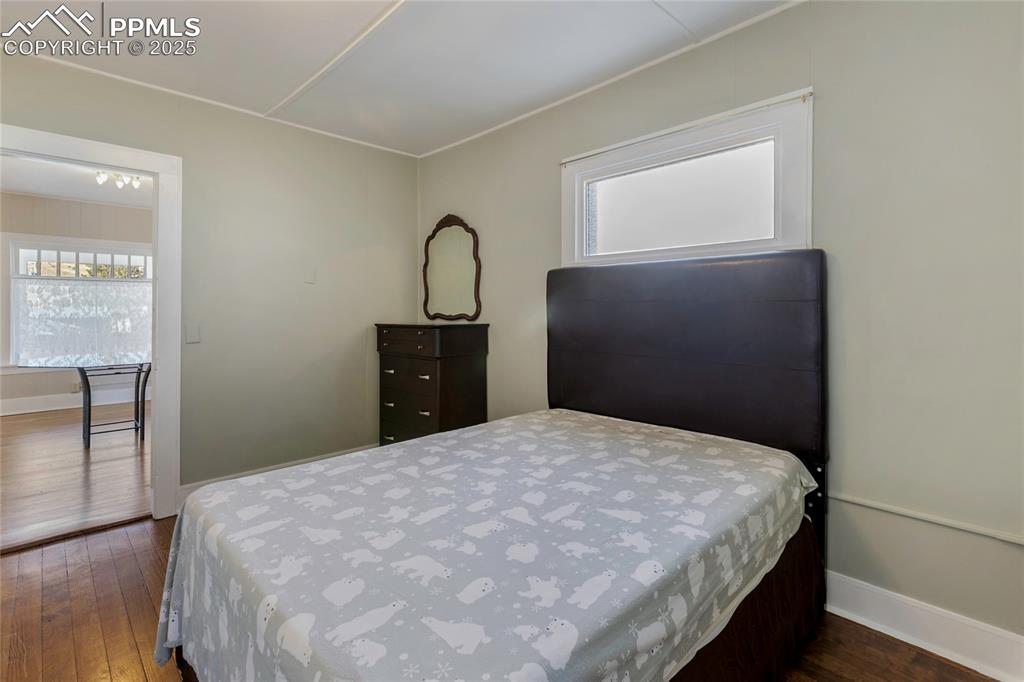 Image 24 of 49: Bedroom featuring dark wood-style flooring and multiple windows