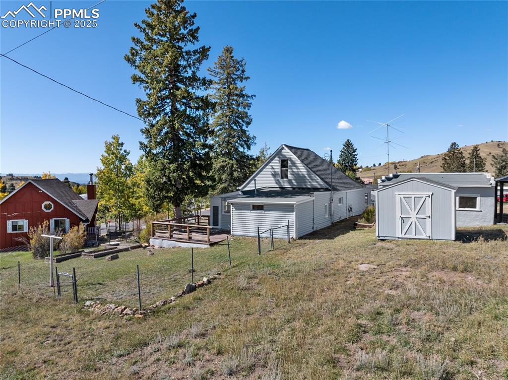 Image 38 of 49: View of yard with a storage shed, a garden, and a deck with mountain view