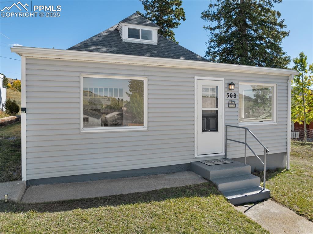 Image 7 of 49: Bungalow-style home featuring roof with shingles and a front lawn