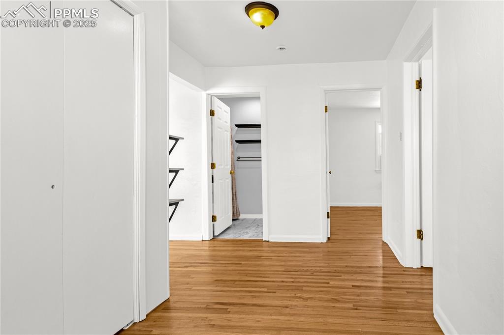 Image 16 of 25: Corridor with baseboards and light wood-type flooring