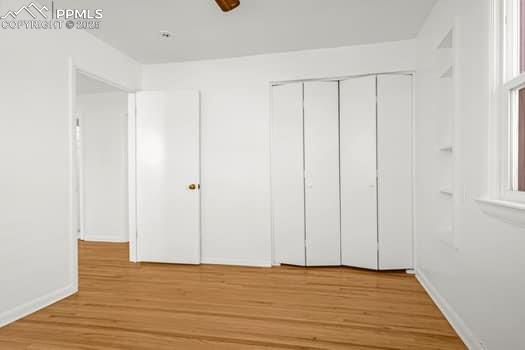 Image 19 of 25: Unfurnished bedroom featuring light wood-style floors, a closet, and basebo