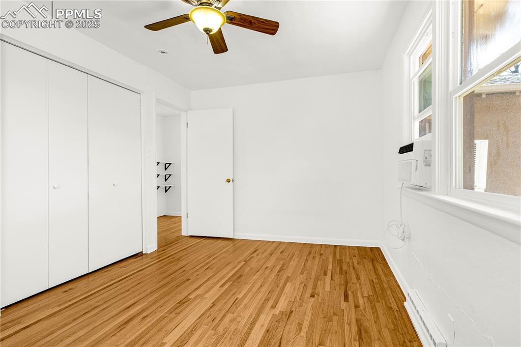 Image 22 of 25: Unfurnished bedroom with baseboards, a ceiling fan, light wood-style floors