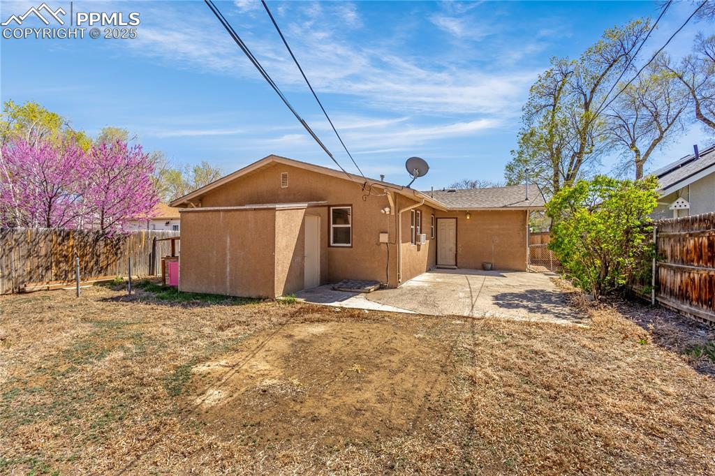 Image 23 of 25: Back of property with a patio area, a fenced backyard, and stucco siding