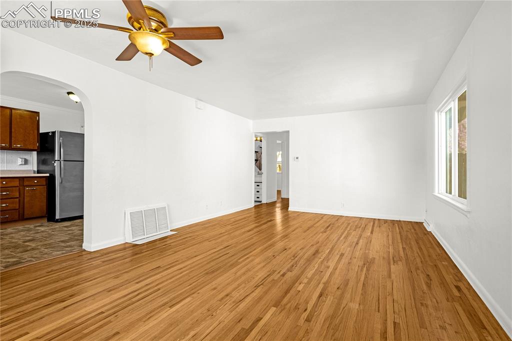 Image 3 of 25: Unfurnished living room featuring visible vents, arched walkways, baseboard