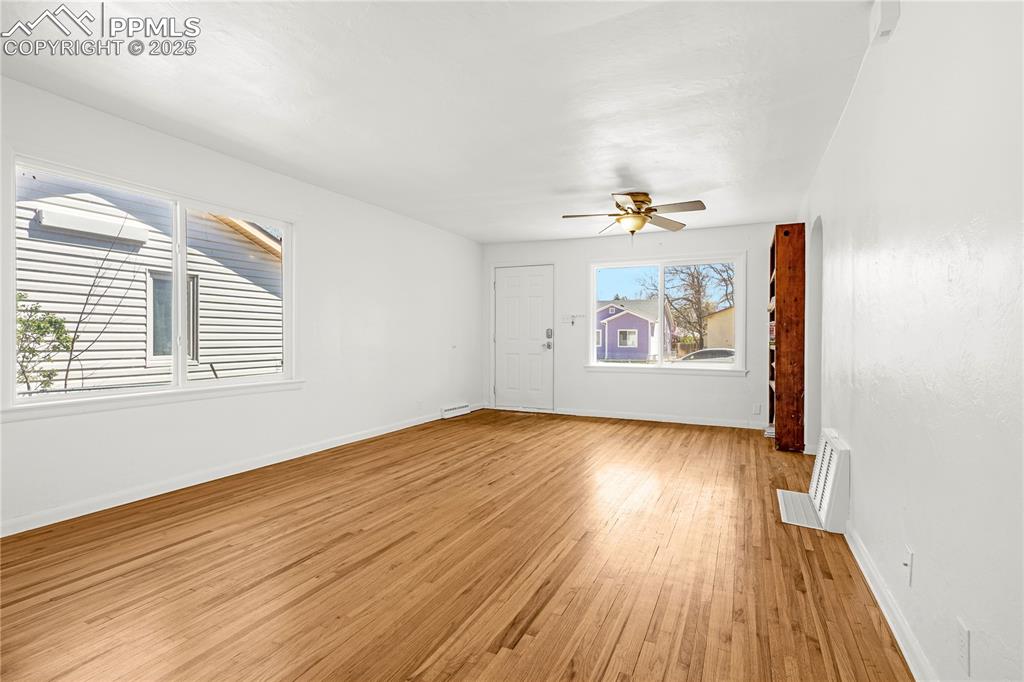 Image 4 of 25: Unfurnished living room featuring visible vents, light wood-style flooring,