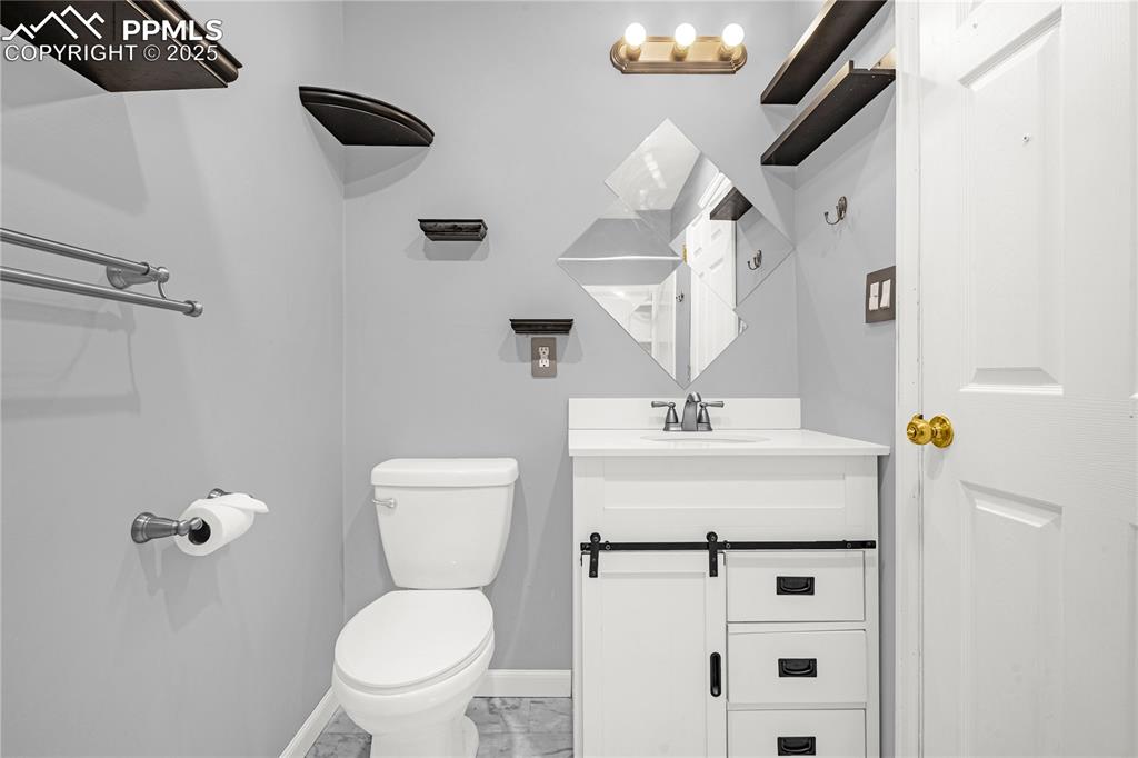 Image 8 of 25: Bathroom with vanity, marble finish floor, baseboards, and toilet