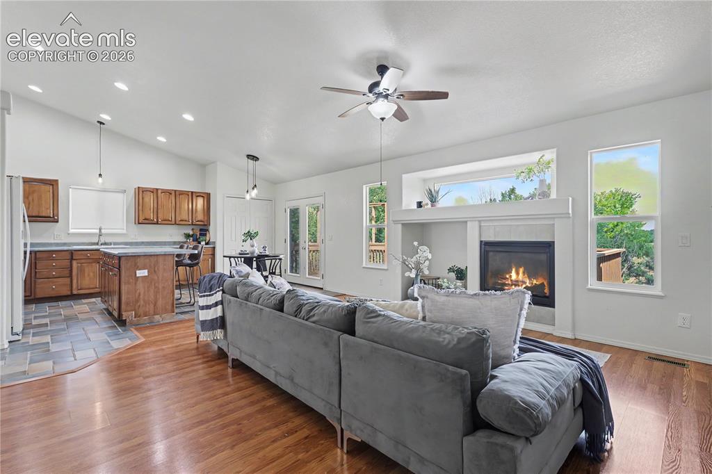 Image 11 of 41: Open-concept living space featuring wood-finish flooring, a tiled kitchen a