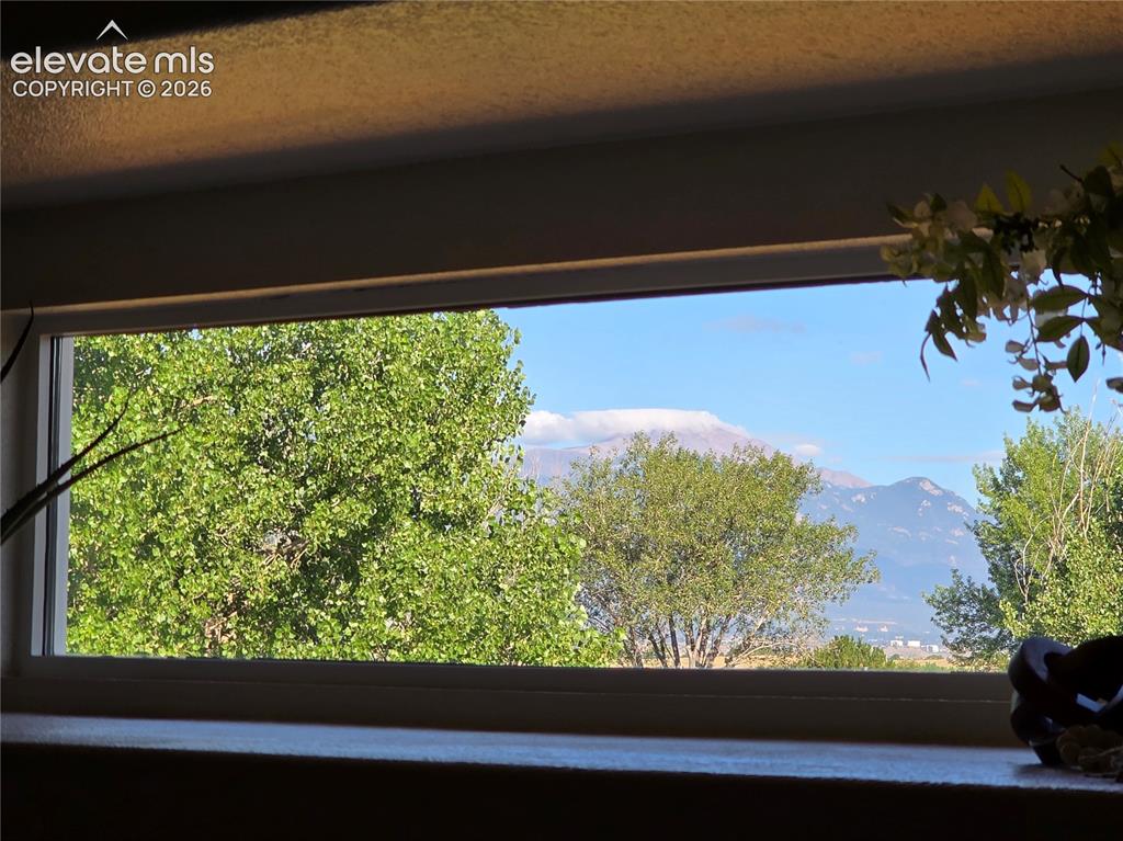 Image 12 of 41: Seller Provided Photo of View of Pikes Peak through Living Room Picture Fra