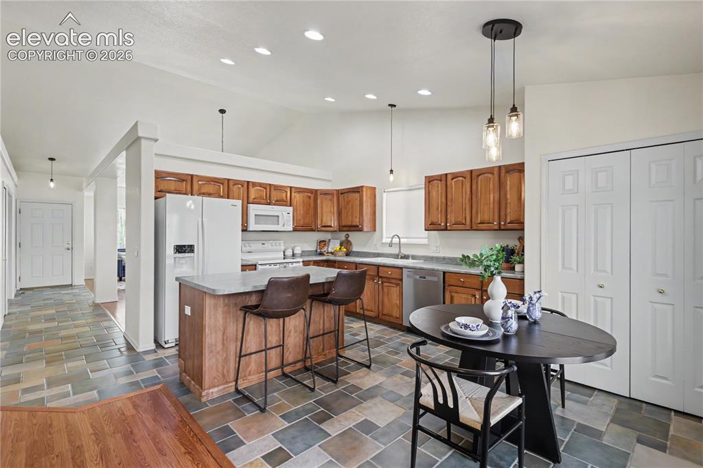 Image 13 of 41: Kitchen featuring wood cabinetry, stone-look countertops, and stainless ste