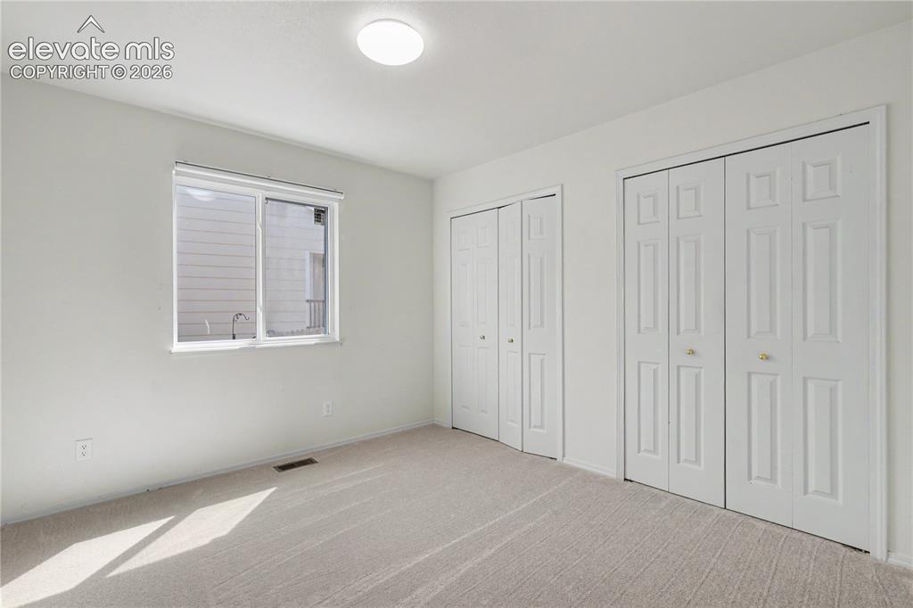Image 24 of 41: Neutral-toned carpeting extends throughout this interior space, featuring a