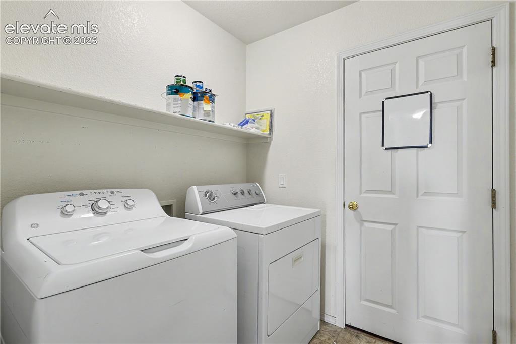 Image 27 of 41: Dedicated laundry area featuring a built-in wall shelf and a paneled door w
