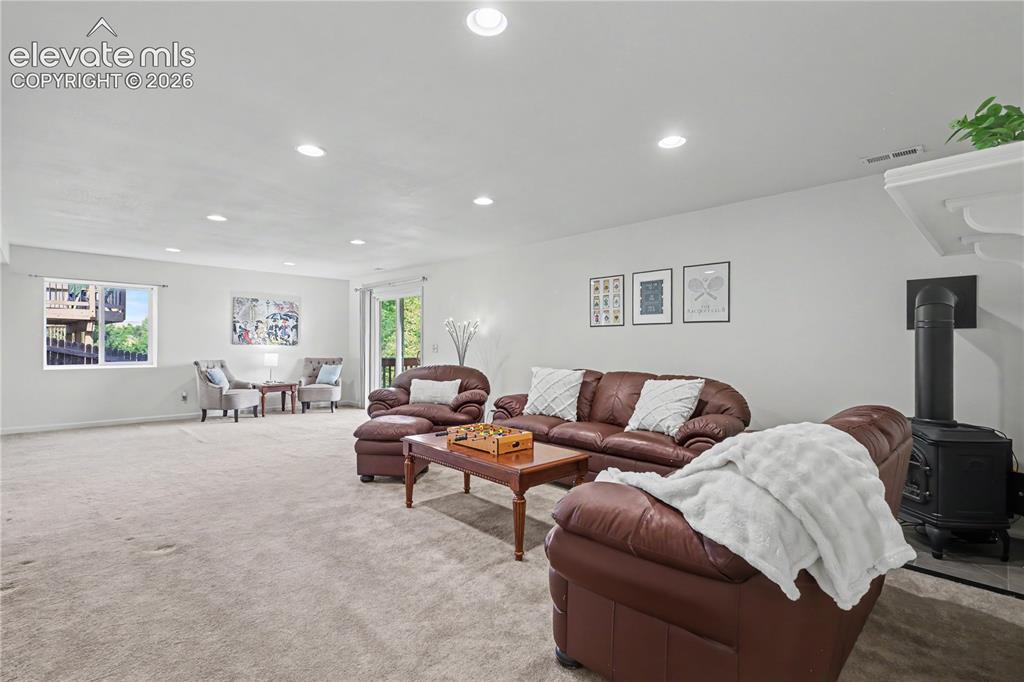 Image 28 of 41: Spacious carpeted room featuring recessed lighting, a built-in wood-burning