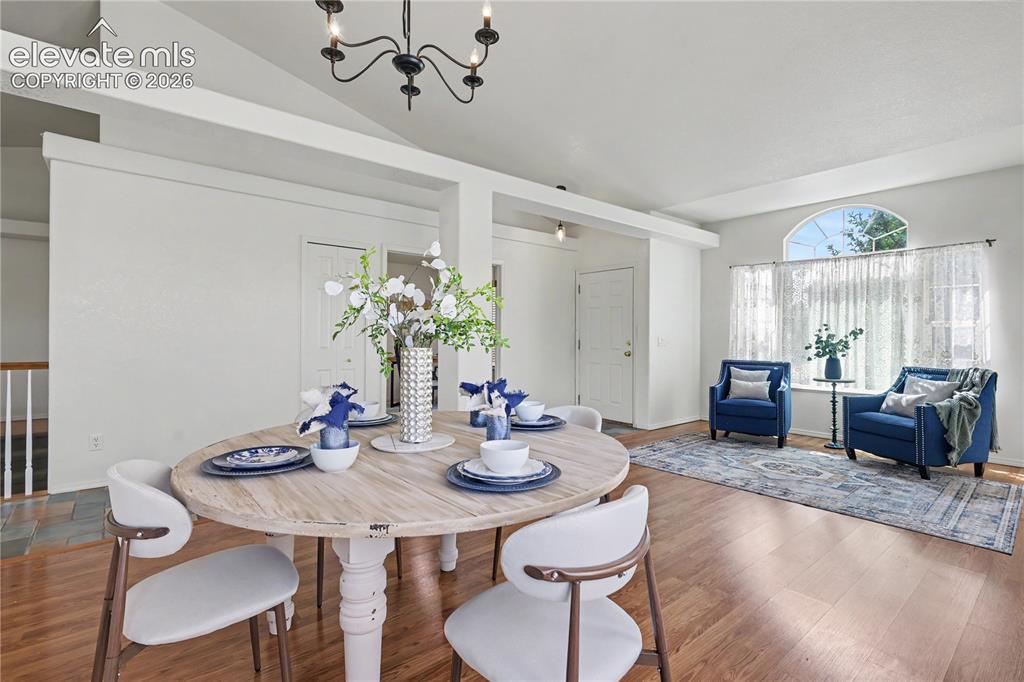 Image 3 of 41: Dining area featuring a wood-finish round table and a black metal chandelie