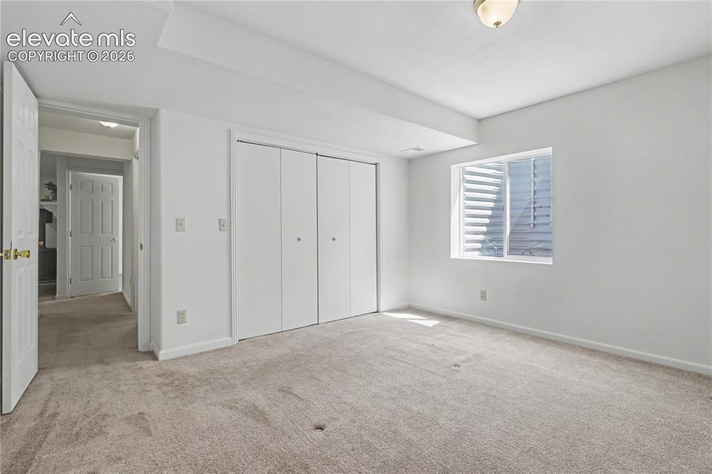 Image 31 of 41: Spacious room featuring neutral carpeting, white walls, and a large window