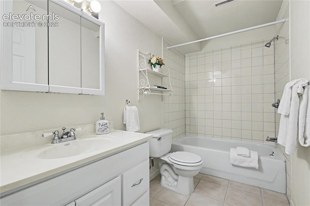 Image 33 of 41: Bathroom featuring a white vanity with an integrated sink, chrome faucet, a