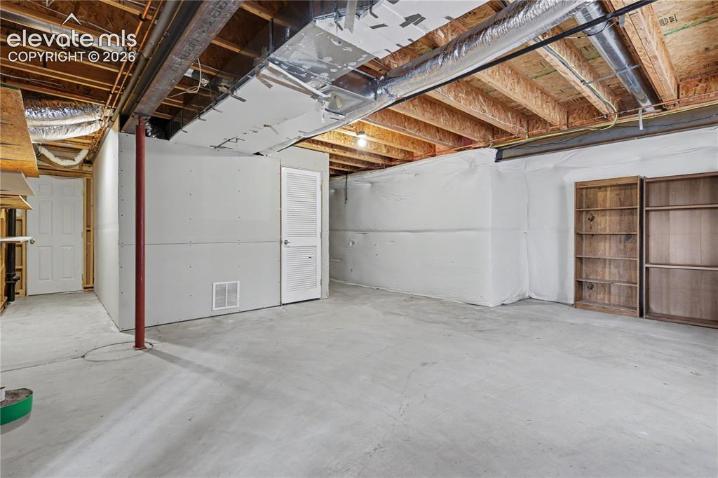 Image 34 of 41: Unfinished lower level featuring concrete flooring and exposed ceiling jois
