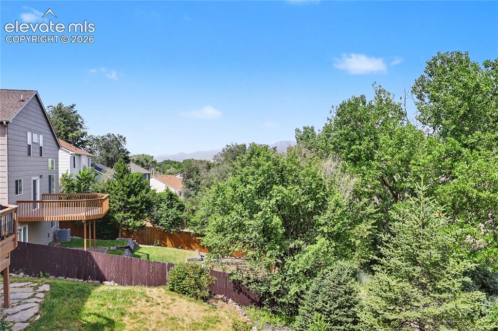 Image 36 of 41: Expansive backyard featuring a multi-level wood deck, privacy fencing, and