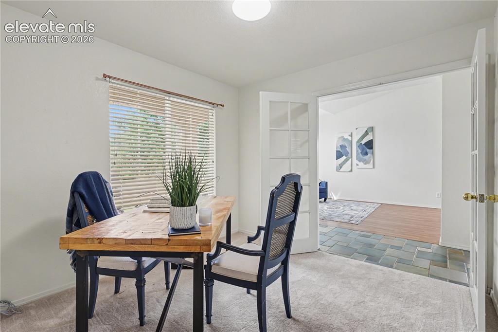 Image 7 of 41: Versatile room featuring light carpeting, a large window with horizontal bl