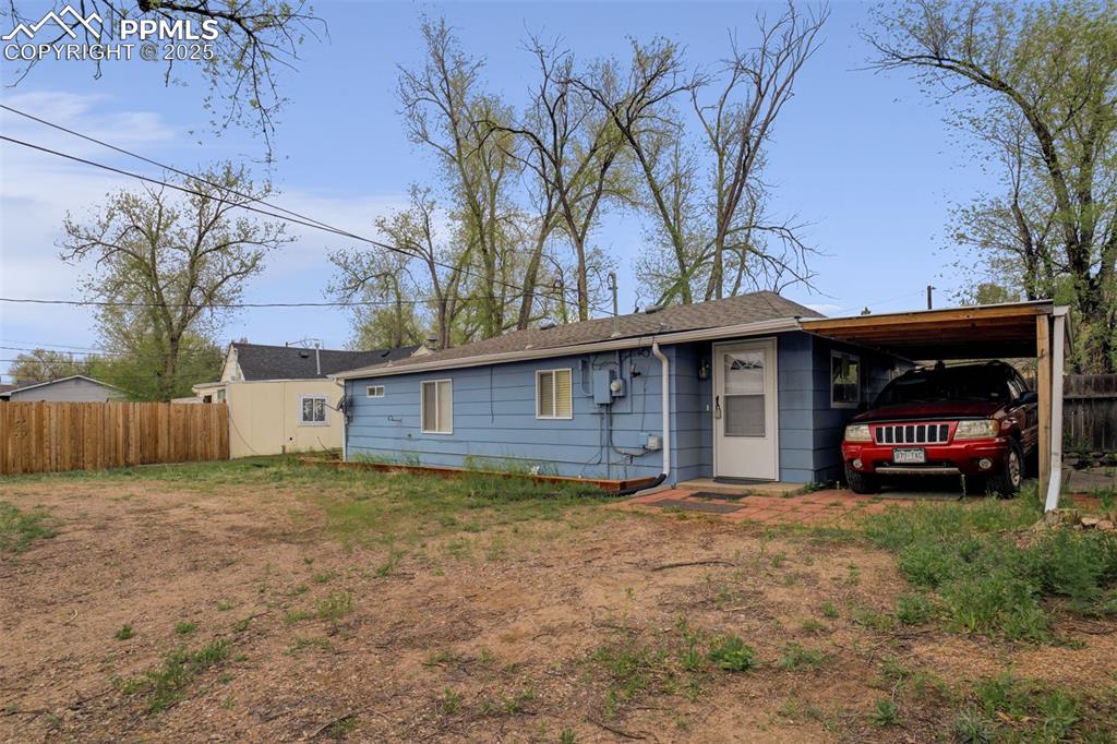 Image 20 of 22: View of front facade with a carport and roof with shingles