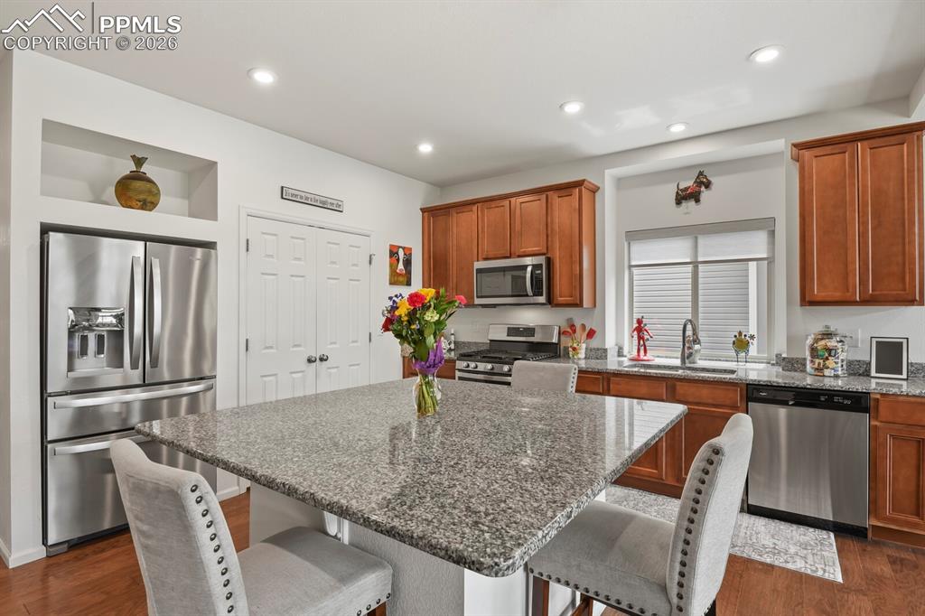 Image 10 of 39: Kitchen featuring a central island with granite countertop, stainless steel