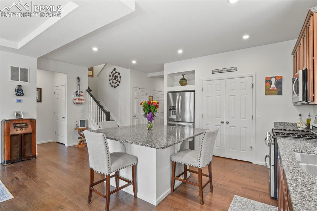 Image 11 of 39: Kitchen featuring a granite-topped island with seating, stainless steel app
