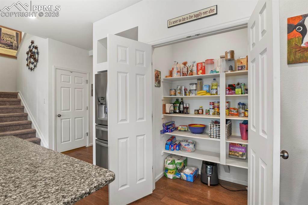 Image 13 of 39: Open pantry featuring multiple levels of built-in shelving providing ample