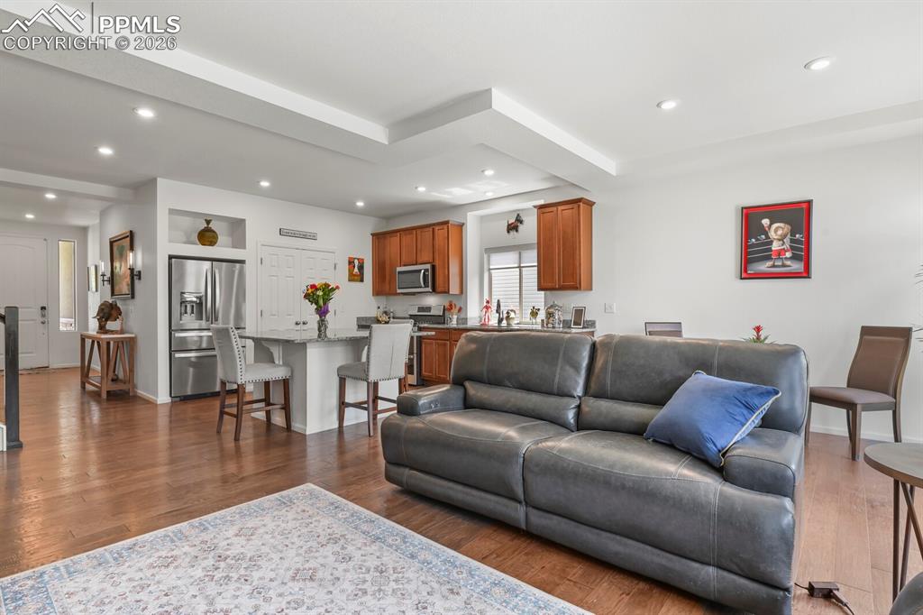 Image 15 of 39: Open-concept living area featuring wood-finish flooring, recessed lighting