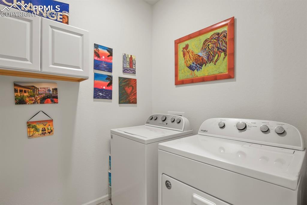 Image 26 of 39: Main level laundry area featuring white upper cabinetry