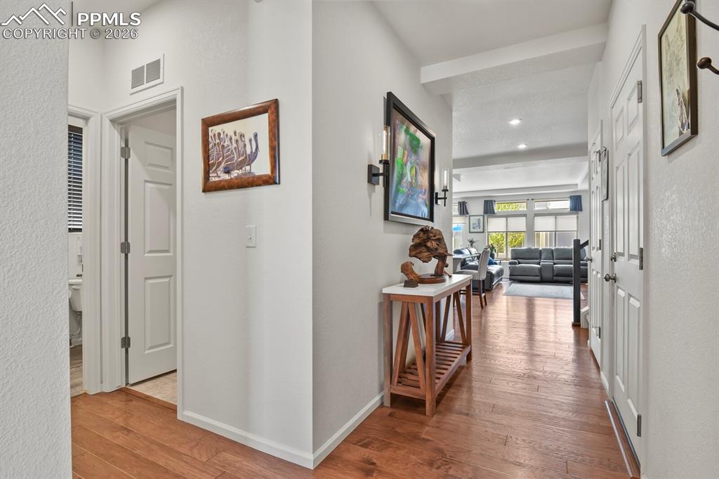 Image 4 of 39: Warm wood-finish flooring extending through the hallway