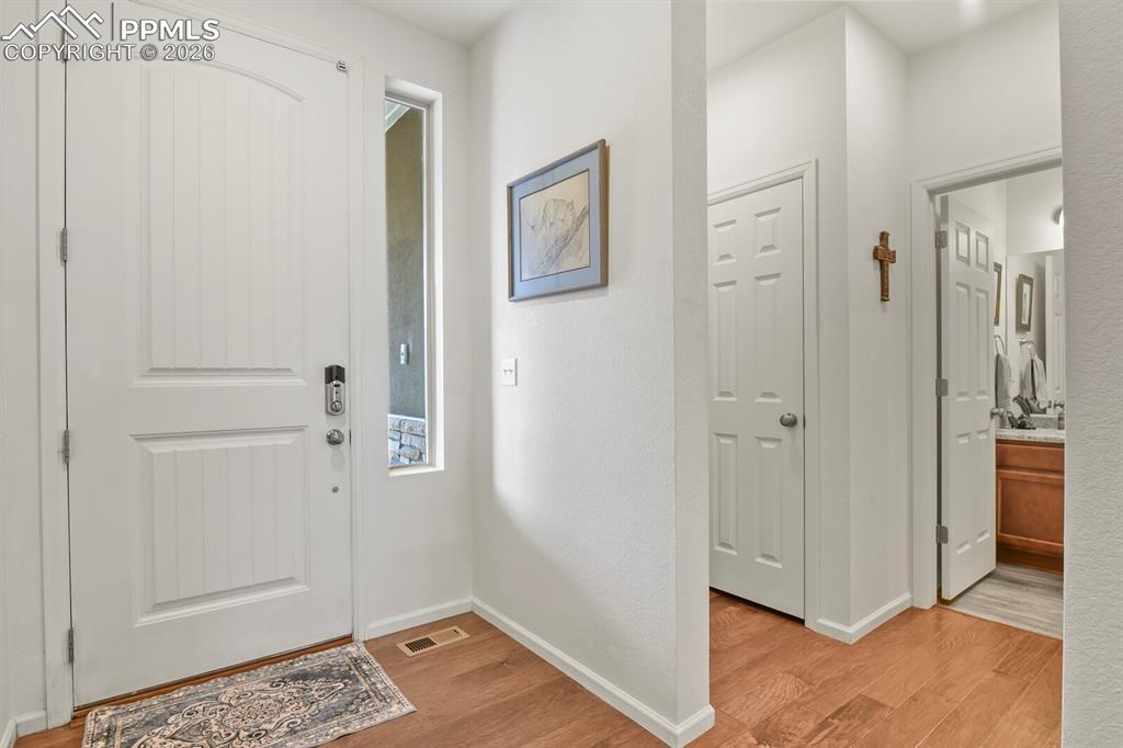 Image 5 of 39: Entryway featuring wood-finish flooring, a white paneled front door with a