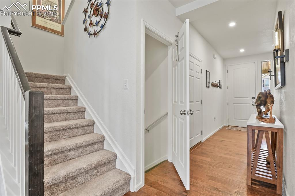 Image 7 of 39: Carpeted staircase featuring a dark-stained wood handrail and white baluste