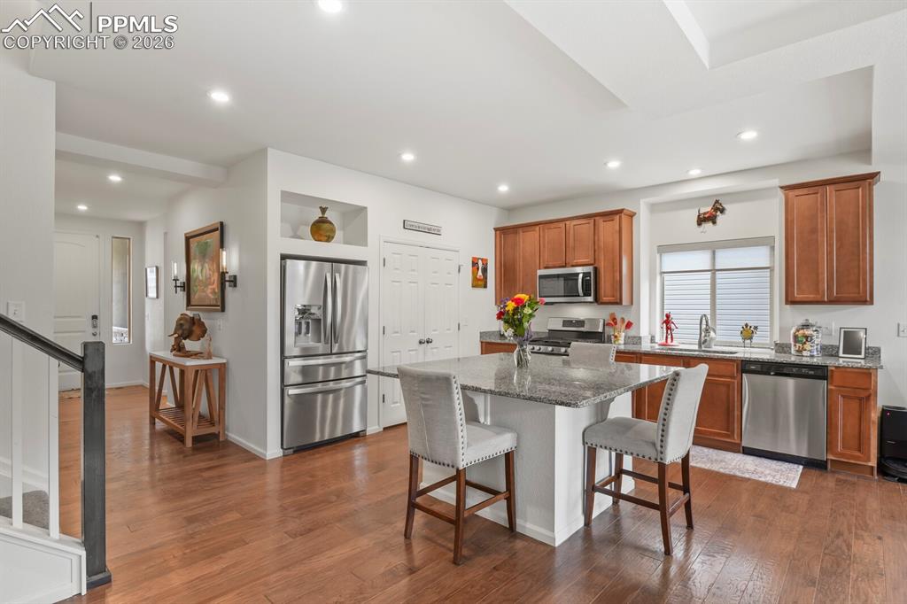 Image 9 of 39: Kitchen featuring a central island with granite countertop, stainless steel