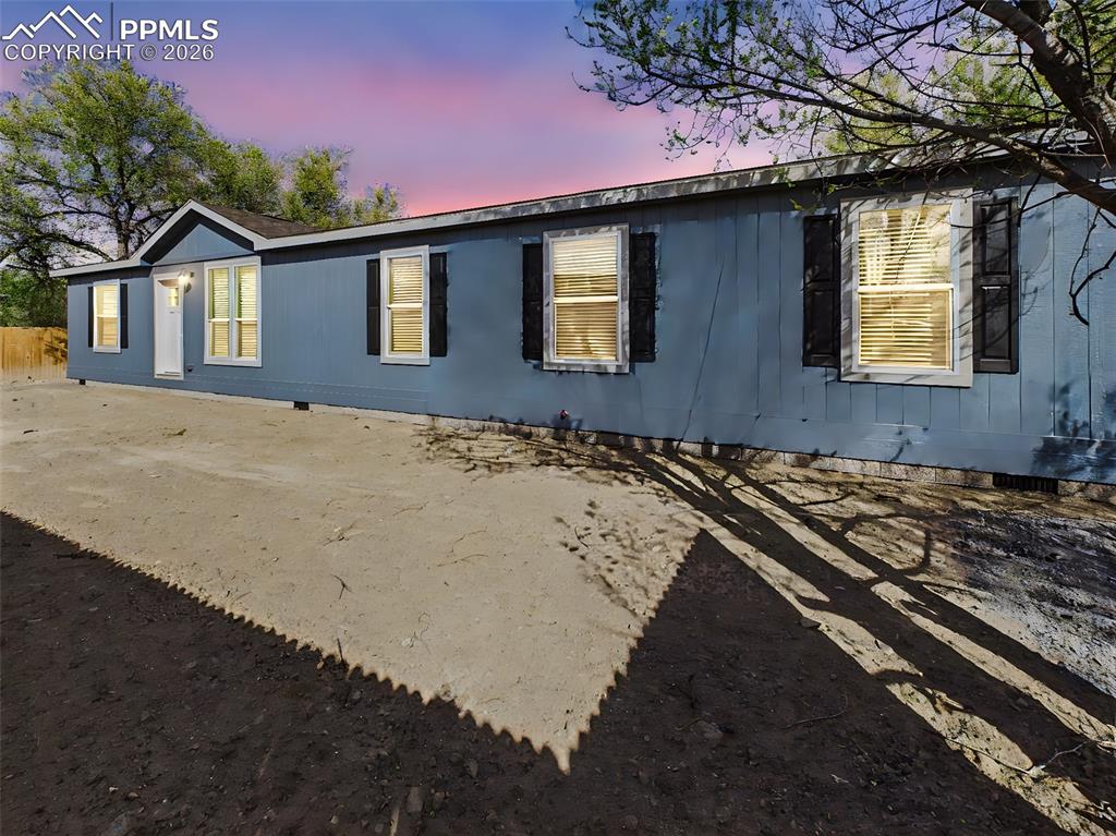 Image 1 of 50: Expansive front yard with mature trees and fencing, offering space for outd