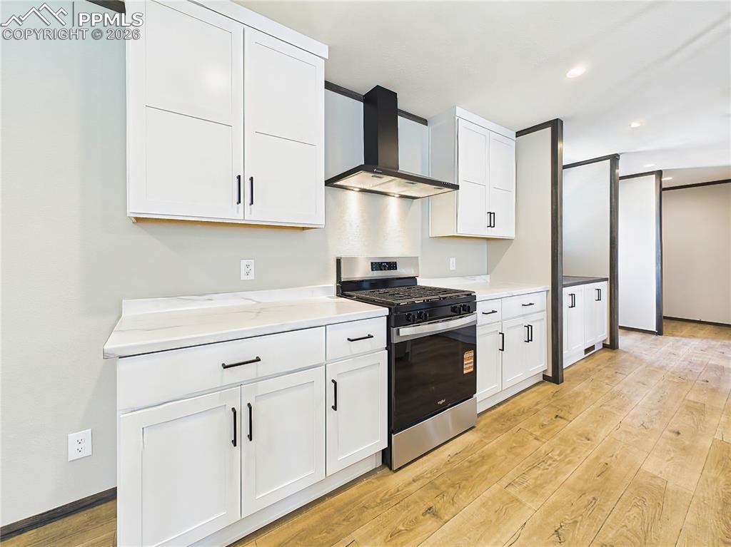 Image 16 of 50: Kitchen – Updated kitchen with sleek countertops, gas range, and vent hood,