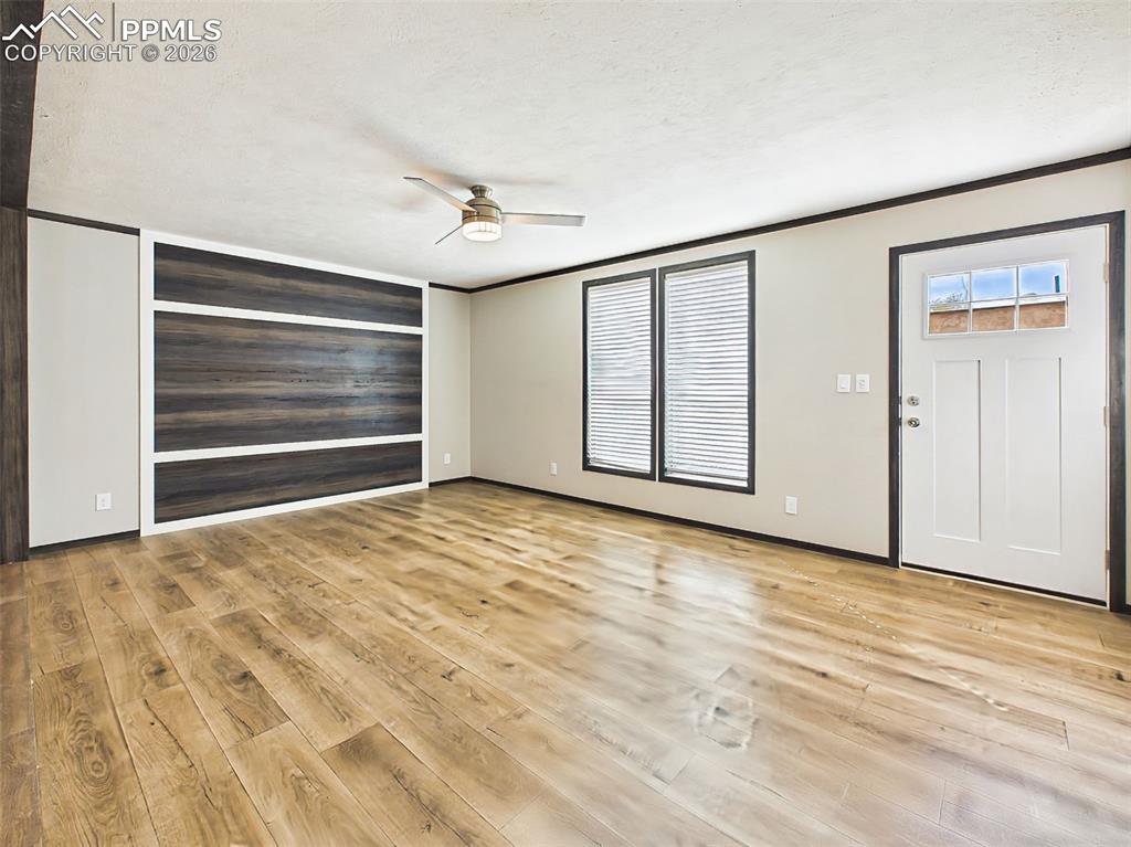Image 2 of 50: Living Area – Open living area with wide-plank flooring, ceiling fan, and a