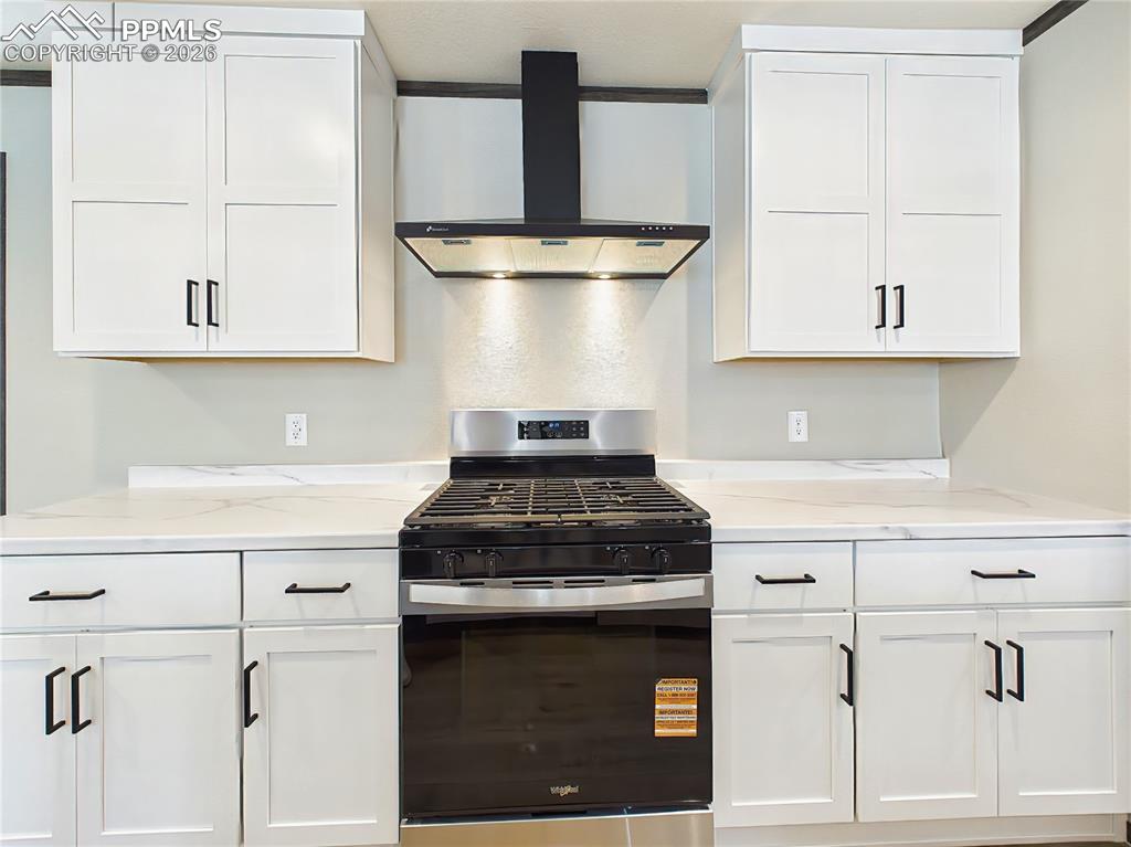 Image 23 of 50: Kitchen – Updated kitchen with sleek countertops, gas range, and vent hood,