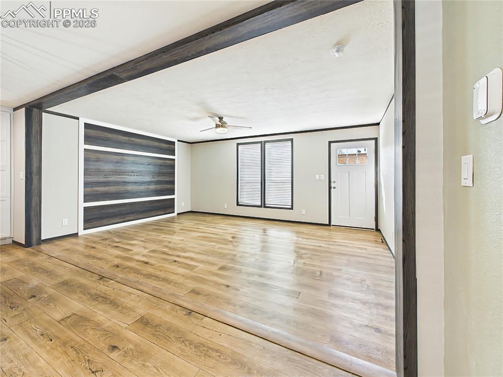 Image 3 of 50: Living Area – Open living area with wide-plank flooring, ceiling fan, and a