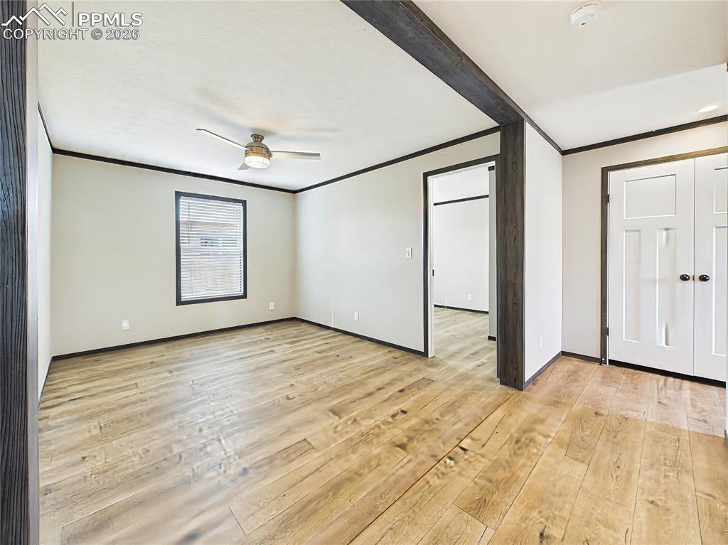 Image 34 of 50: Open family area with wide-plank flooring, ceiling fan, and a flexible layo