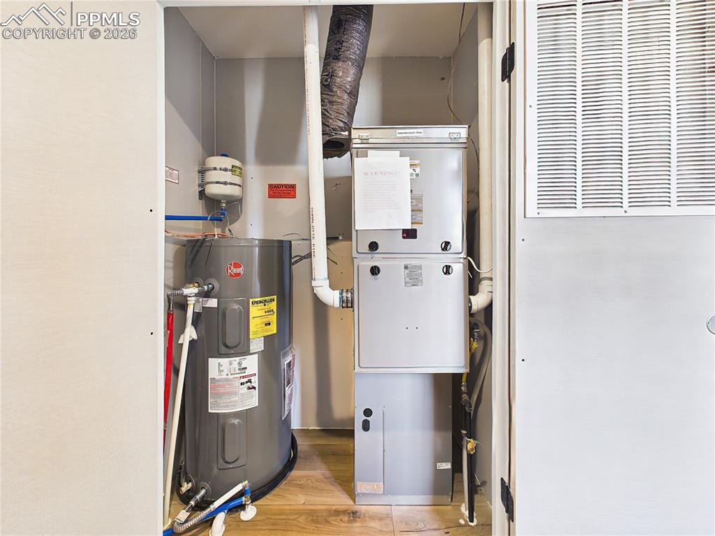 Image 45 of 50: Utility Room – Mechanical room housing water heater and furnace, offering e