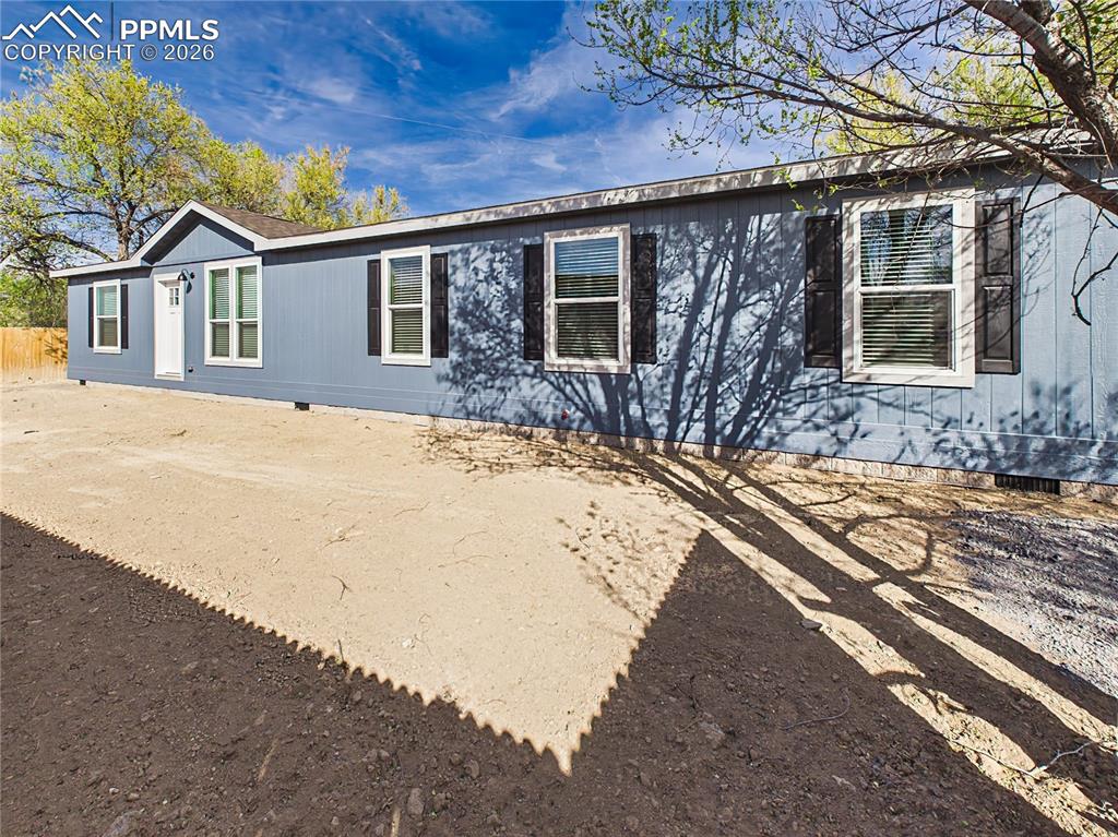 Image 47 of 50: Long front elevation with ample yard space and natural shade from surroundi