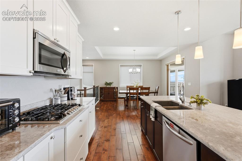 Image 10 of 47: Gourmet kitchen featuring a gas range, stainless steel appliances, white up